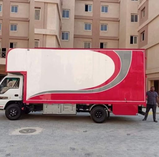 شاحنة نقل أثاث MD Transport الحمراء مجهزة ومغلقة أمام مبنى سكني في القاهرة